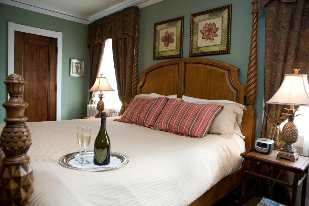 a bedroom with a bed with a bottle and a glass at The Belvedere Inn & Restaurant in Saugatuck