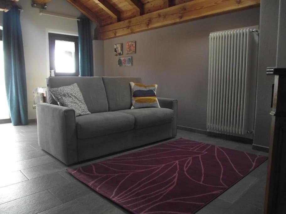 a living room with a couch and a rug at Maison Pépé et Mémé in Torgnon