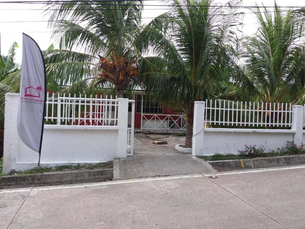 Una cerca blanca con un paraguas blanco. en Coral Inn Providencia Isla, en Providencia