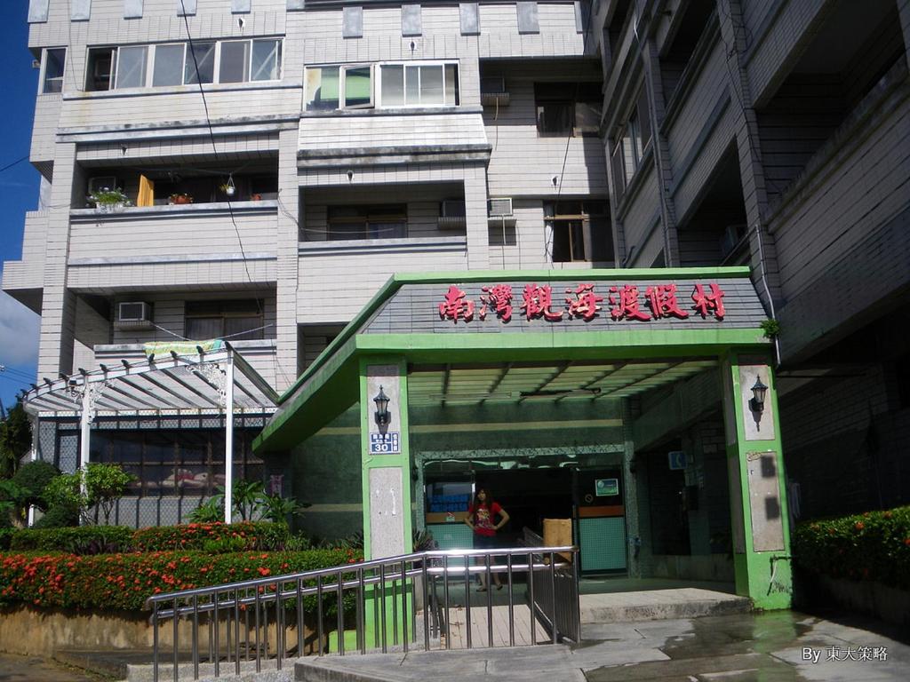 a building with a sign in front of a building at Herbaceous-Inn in Nanwan