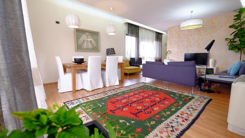 a living room with a table and a dining room at Galeria Apartment in Tirana