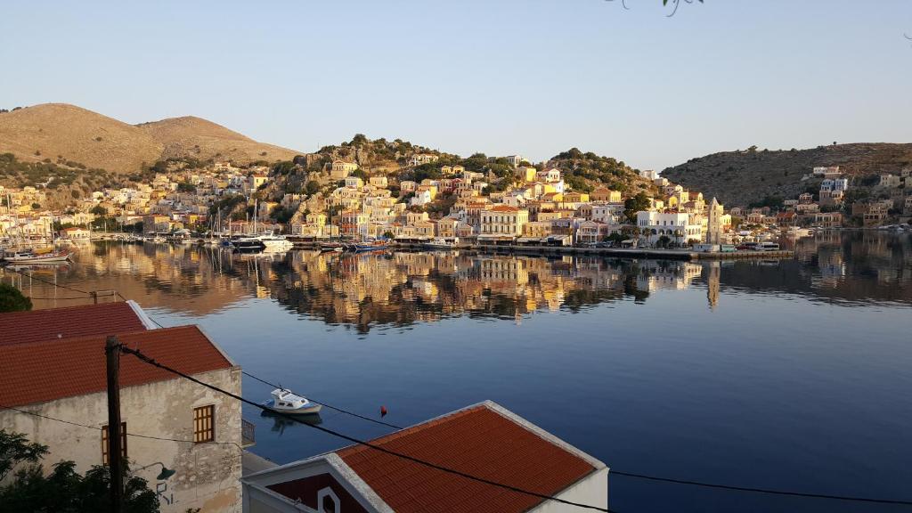 una gran masa de agua con casas y barcos en Pitini, en Symi