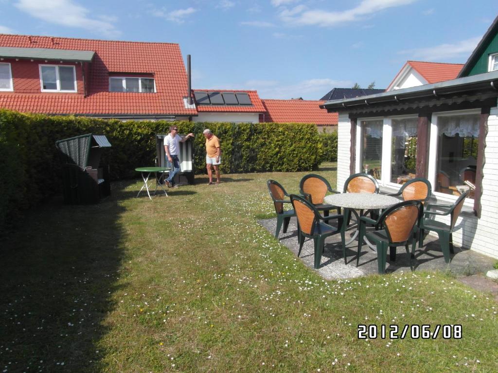 een groep mensen in een tuin met een tafel en stoelen bij Pension zum Meer in Breege