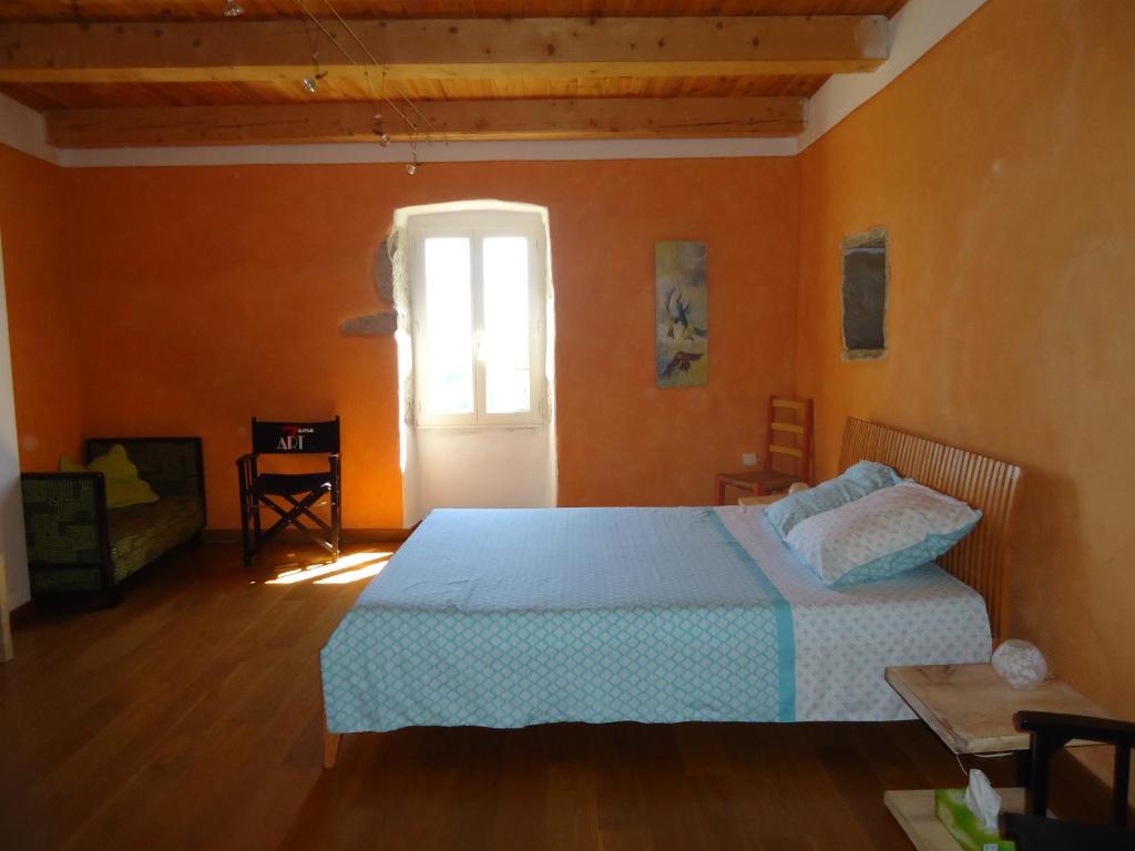 バンヌにあるLe vieux tilleulのベッドルーム1室(オレンジ色の壁のベッド1台付)