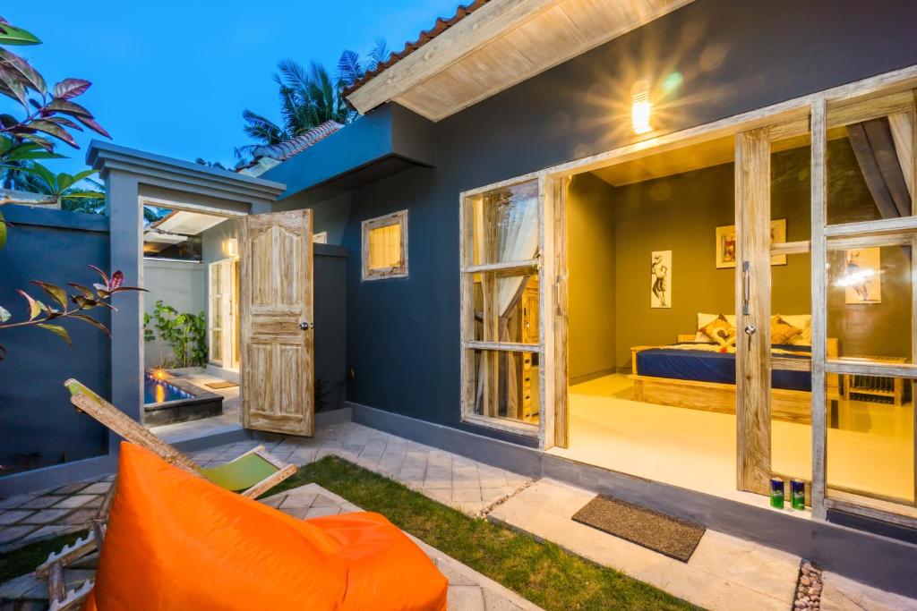 a bedroom in a villa with an orange couch at Kawans Inn in Nusa Lembongan