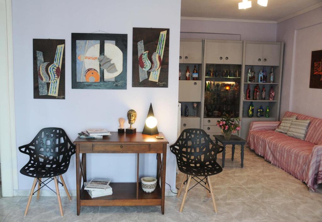 uma sala de estar com uma secretária, cadeiras e um sofá em House of Arts em Pélla