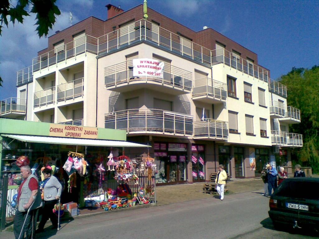 a large white building with people walking in front of it at Sonatka w Apartamentowcu Sonata in Międzywodzie