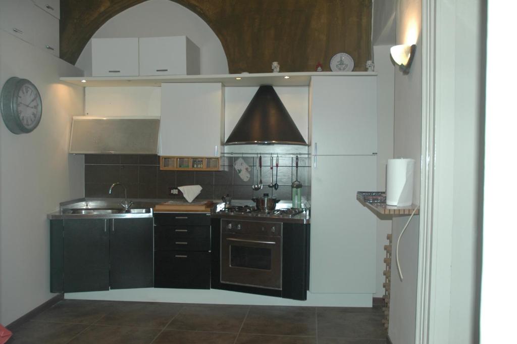 カターニアにあるDetached House "Al Vicoletto"のキッチン(黒いキャビネット、シンク、コンロ付)
