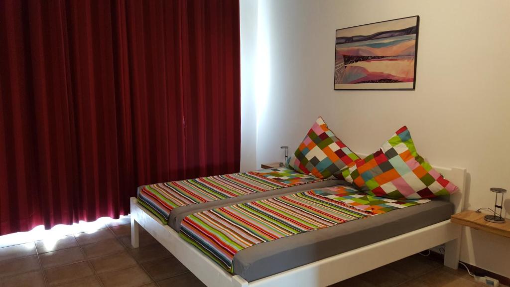 a bed in a room with a red curtain at Casa Ingrid in Eforie Nord
