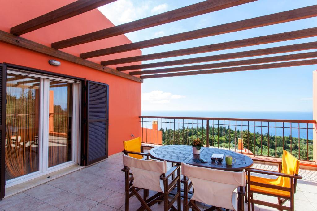 a patio with a table and chairs on a balcony at Scorpina Villas in Agios Nikitas