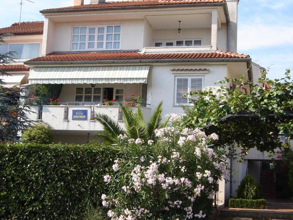 una casa bianca con dei fiori davanti di Apartments Kliman a Rovigno (Rovinj)