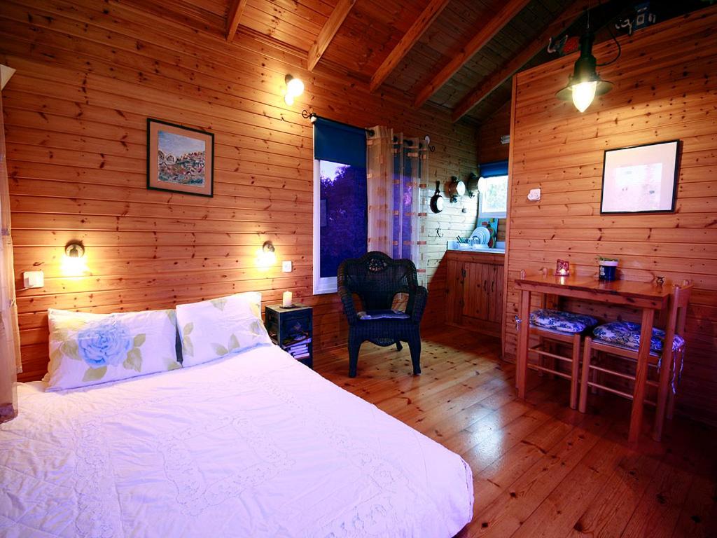 Schlafzimmer mit einem Bett, einem Schreibtisch und einem Stuhl in der Unterkunft Cabin In The View in Hararit