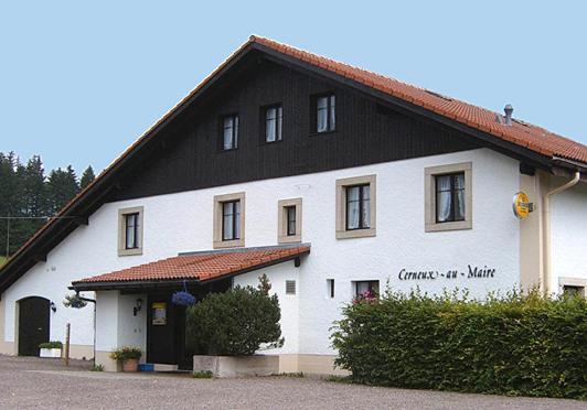 un gran edificio blanco con techo negro en Le Cerneux-au-Maire, en Les Bois