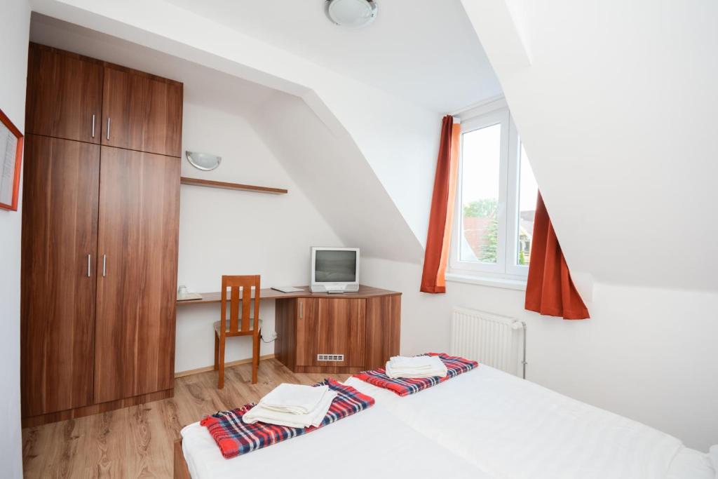 a bedroom with a bed and a desk with a computer at Hethland Zamárdi VSZ Üdülő in Zamárdi