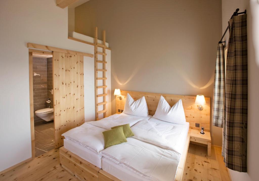 Postel nebo postele na pokoji v ubytování Romantik Hotel Muottas Muragl