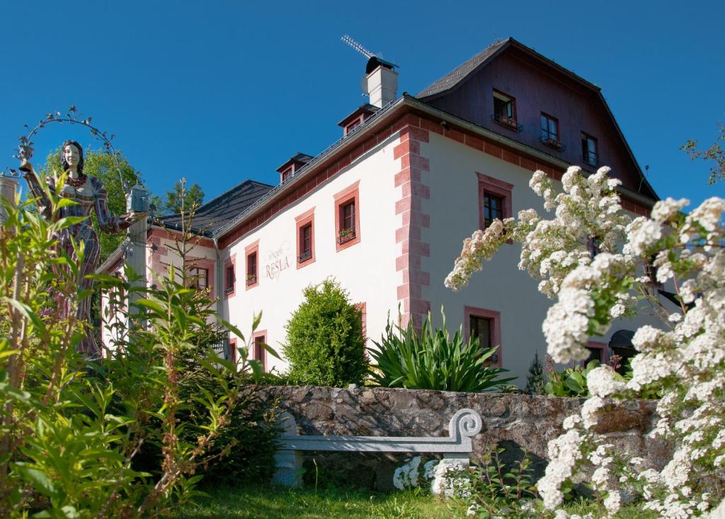 a building with a fence and flowers in front of it at Resla Residence I, II, in Banská Štiavnica