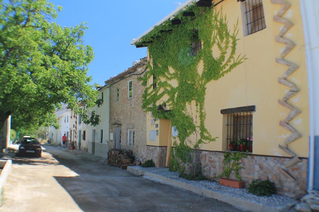 Un edificio con edera sul lato di una strada di Alojamiento Rural El Chico a Fornes