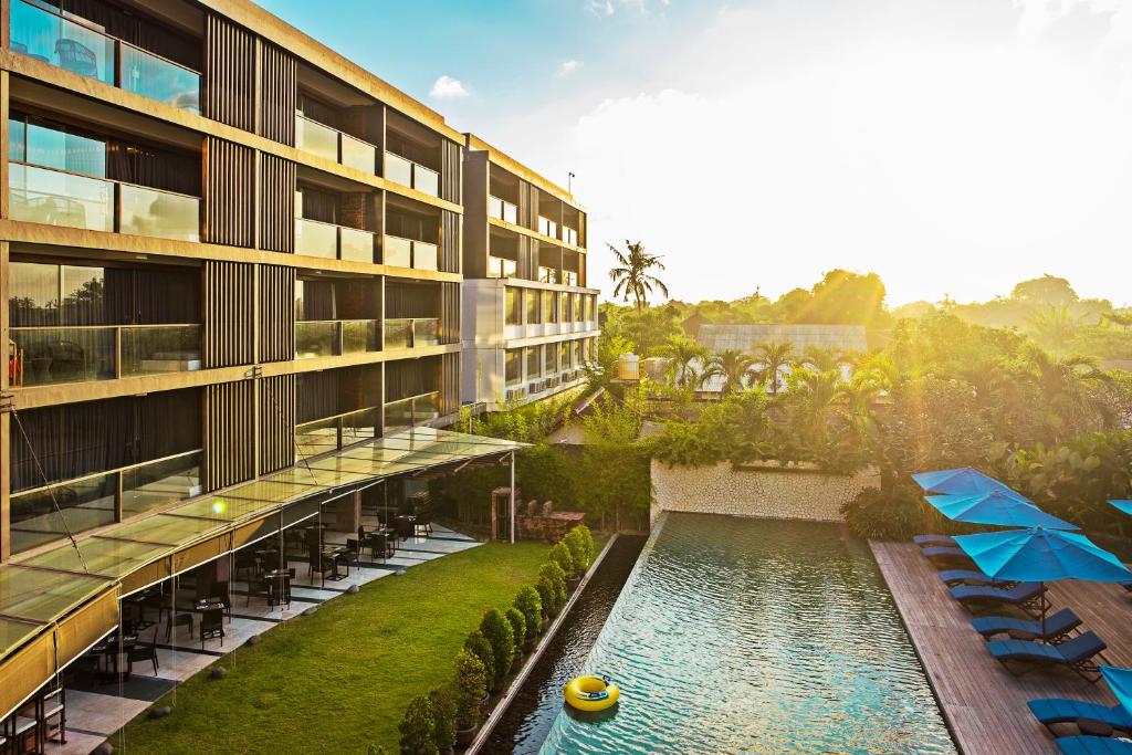 an exterior view of a building with a swimming pool at Suites by Watermark Hotel and Spa in Jimbaran