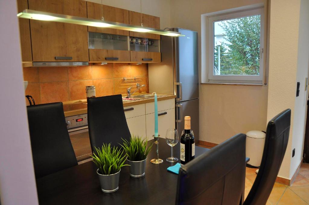 a kitchen with a table with wine bottles and chairs at Nordsternchen Winterberg in Winterberg