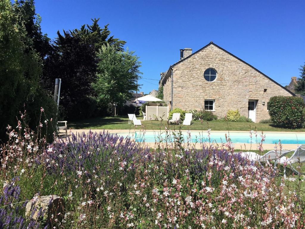 una casa de piedra con una piscina frente a ella en Le clos Saint Aubin, en Carnac