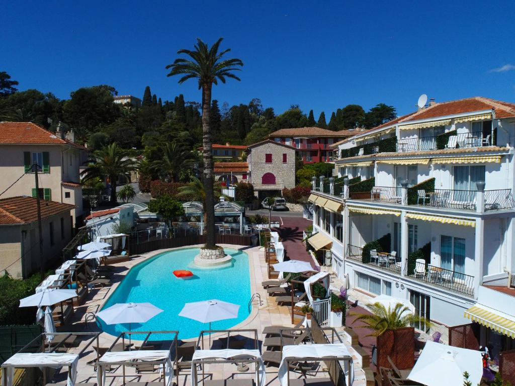 a resort with a pool and chairs and a palm tree at Boutique Hotel & Spa la Villa Cap Ferrat in Saint-Jean-Cap-Ferrat
