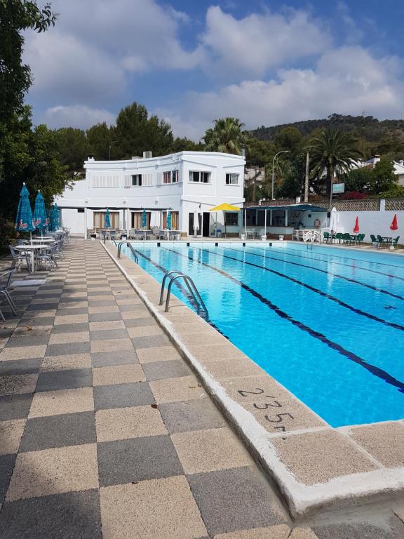 een groot zwembad met een gebouw op de achtergrond bij Son Roqueta in Palma de Mallorca