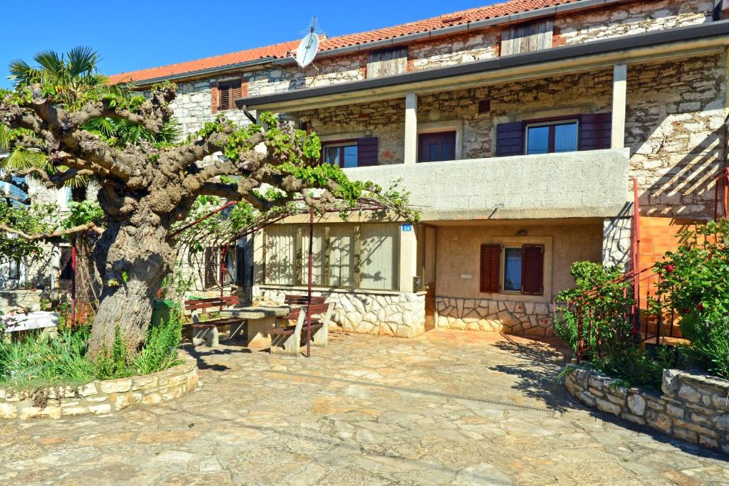 una casa con un árbol delante de ella en Apartment Milena en Umag