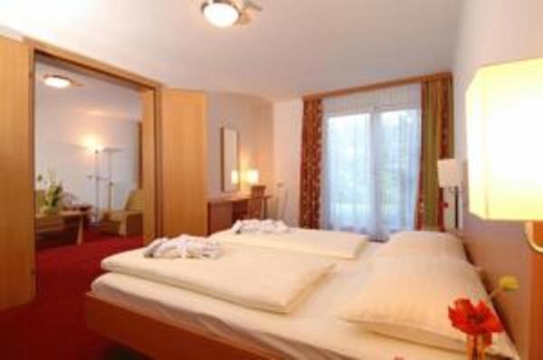 a bedroom with a large white bed with a large mirror at Apartment in Warmbad Villach in Villach