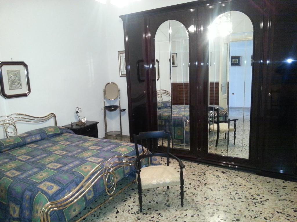 サン・ヴィート・ロ・カーポにあるcasa rosaのベッドルーム1室(ベッド1台、椅子、鏡付)