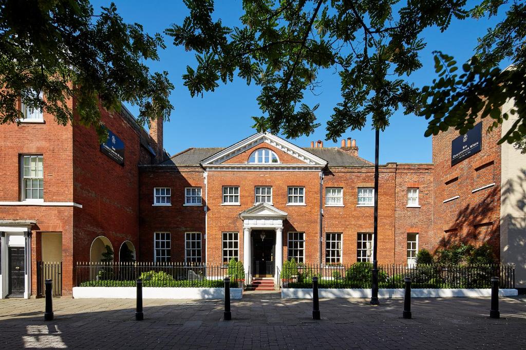 een groot gebouw van rode baksteen met een deur bij Sir Christopher Wren Hotel in Windsor