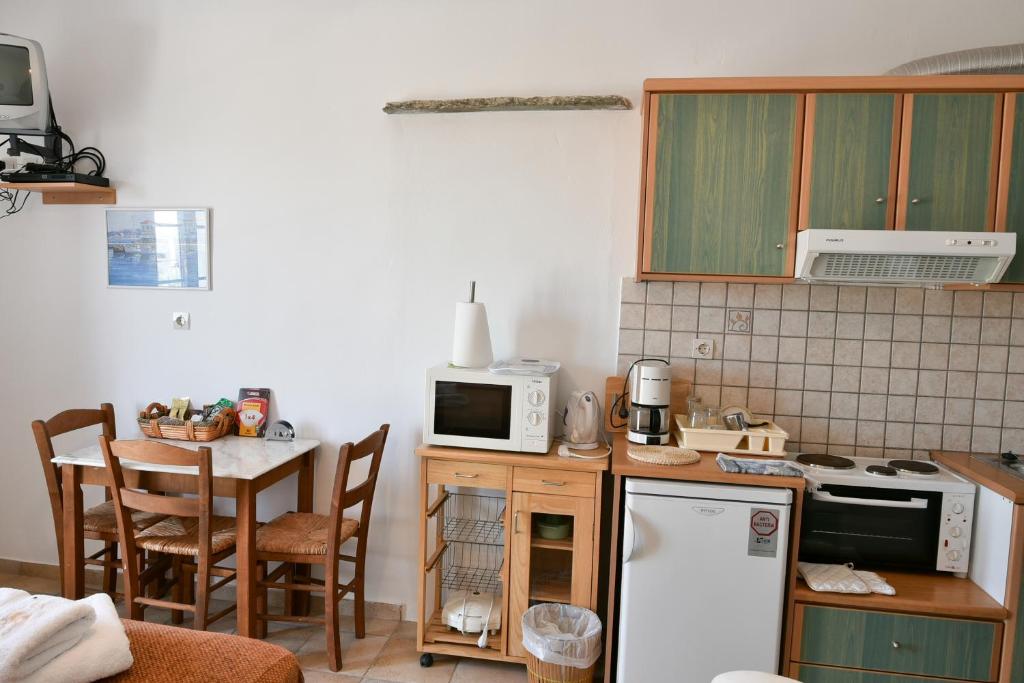 een keuken met een tafel en een witte koelkast bij Standing Stone in Kionia