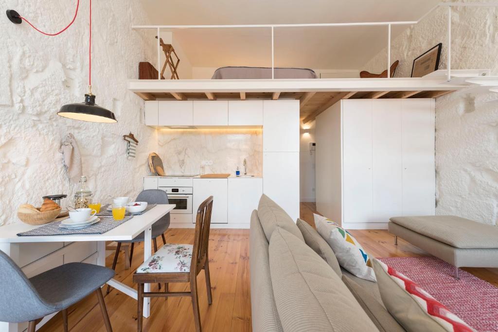 eine Küche und ein Wohnzimmer mit einem Tisch und Stühlen in der Unterkunft LovelyStay - Cativo Mezzanine Studio in Porto