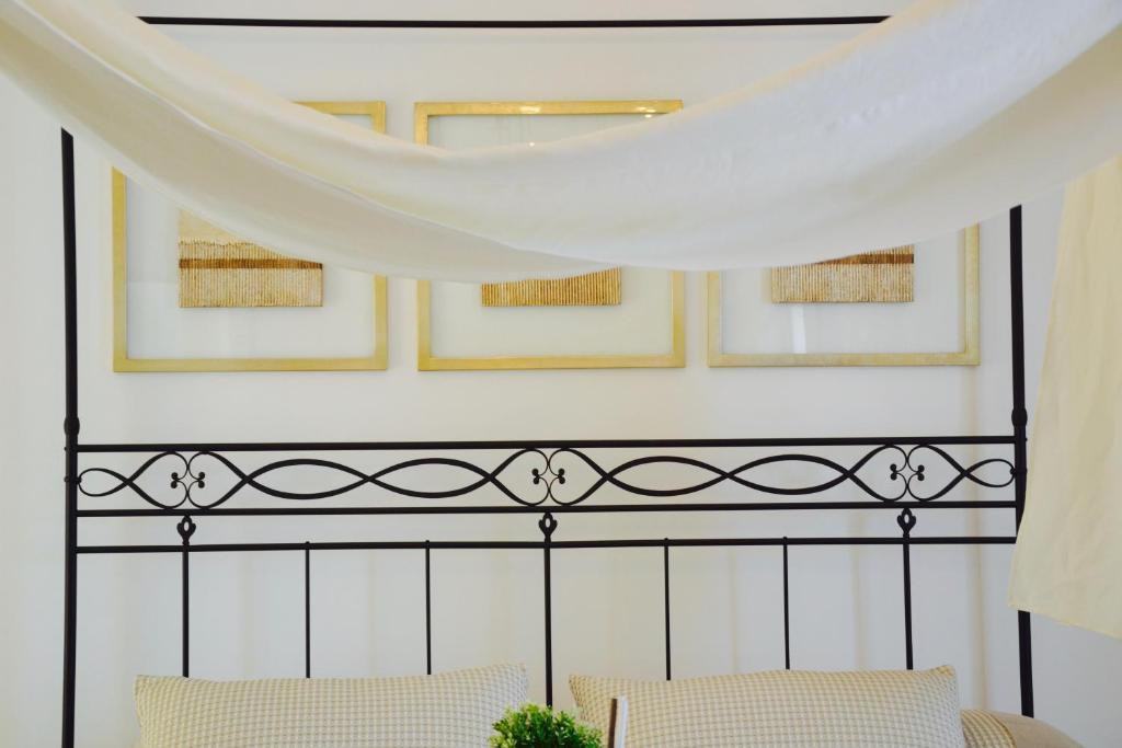 a canopy over a bed with two chairs at Il Bottone al Duomo in Gaeta