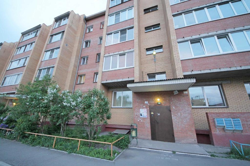 um edifício de tijolos com uma porta em frente em Apartments at Nekrasova 8 em Abakan