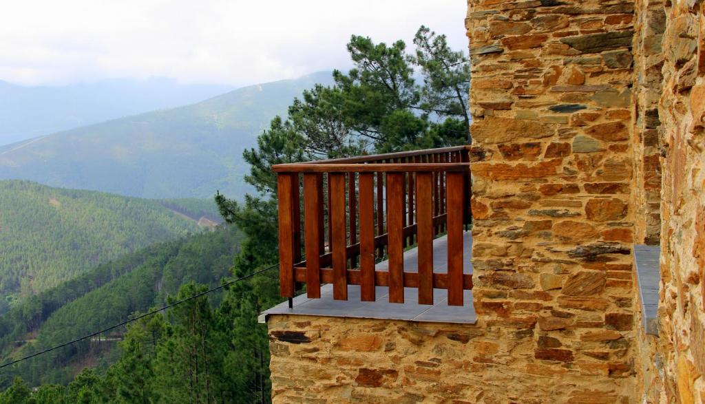 a balcony on the side of a building with mountains in the background at Quinta Do Caramulo in Oliveira do Hospital