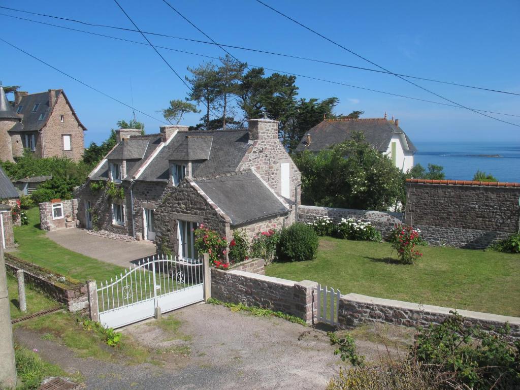 a house with a white fence and a yard at Au Clair de la Dune in Frehel