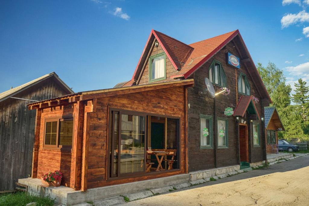 a log cabin with a large window at Apartmani Restoran Durmitor in Žabljak