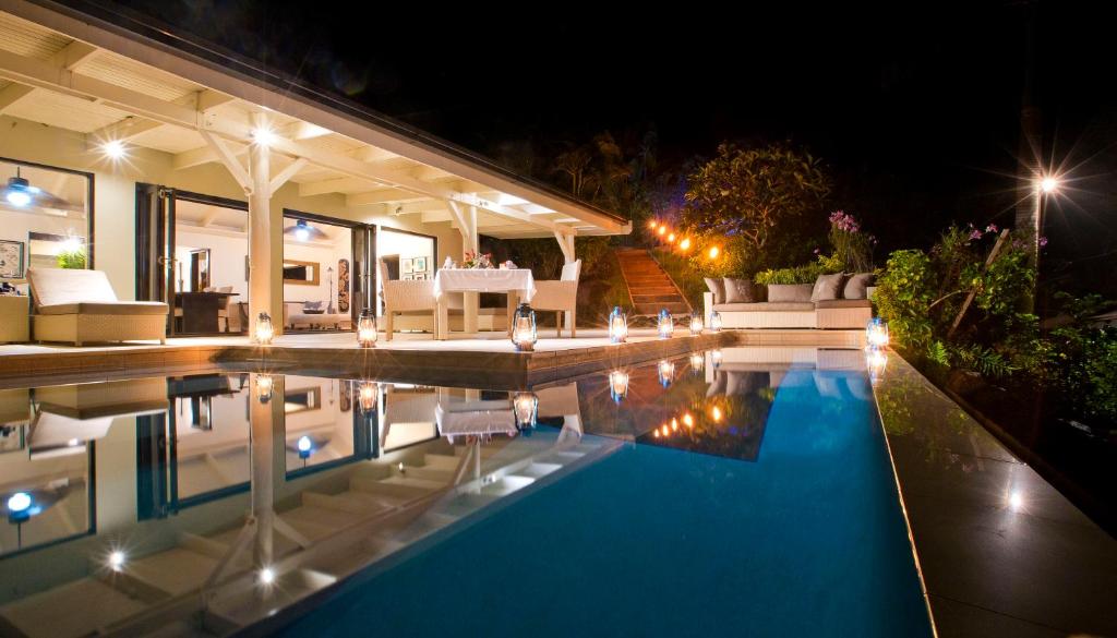 a house with a swimming pool at night at Taveuni Palms Resort in Matei