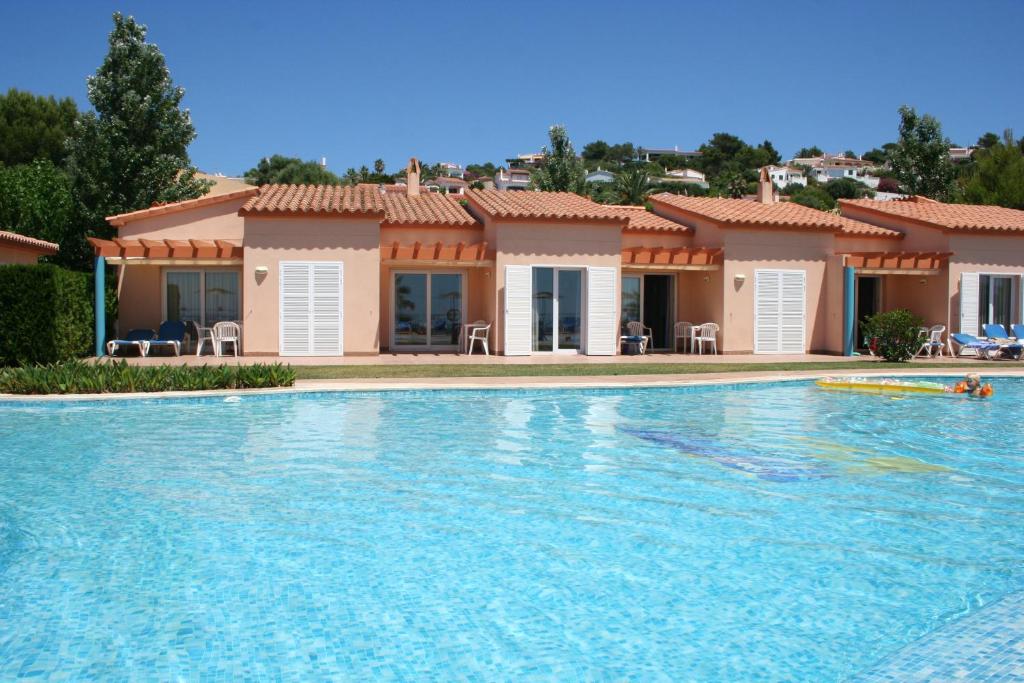 a large swimming pool in front of a house at Apartamentos Mar Blau in Son Bou