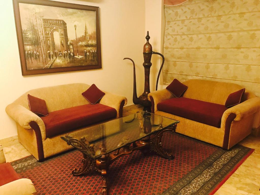 a living room with two couches and a coffee table at Skylink Suites Bed & Breakfast in New Delhi