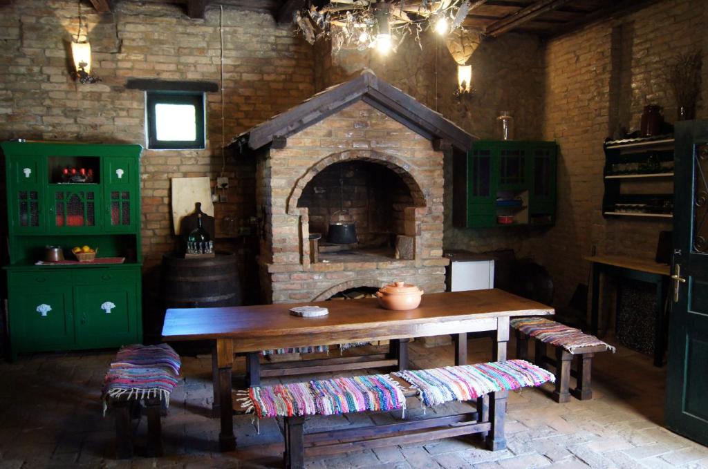 a kitchen with a table and a brick oven at Guest House Stara Baranja in Kneževi Vinogradi