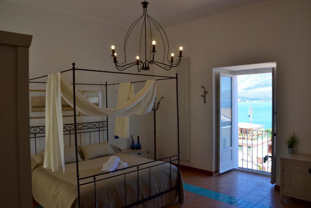 a bedroom with a canopy bed with a view of the ocean at Il Bottone al Duomo in Gaeta