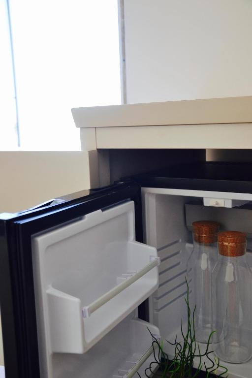 an empty refrigerator with its door open and a plant at Il Bottone al Duomo in Gaeta