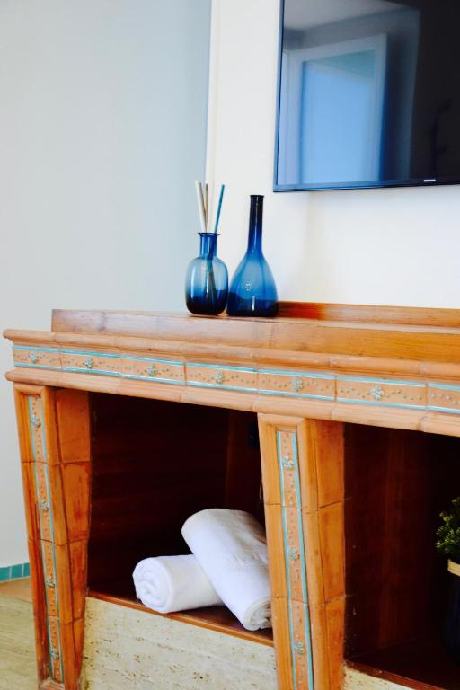 a wooden table with two blue vases and a mirror at Il Bottone al Duomo in Gaeta