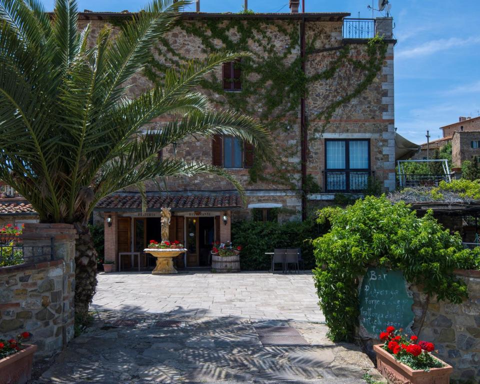 a building with a palm tree in front of it at B&B Locanda Sant'Antimo in Montalcino
