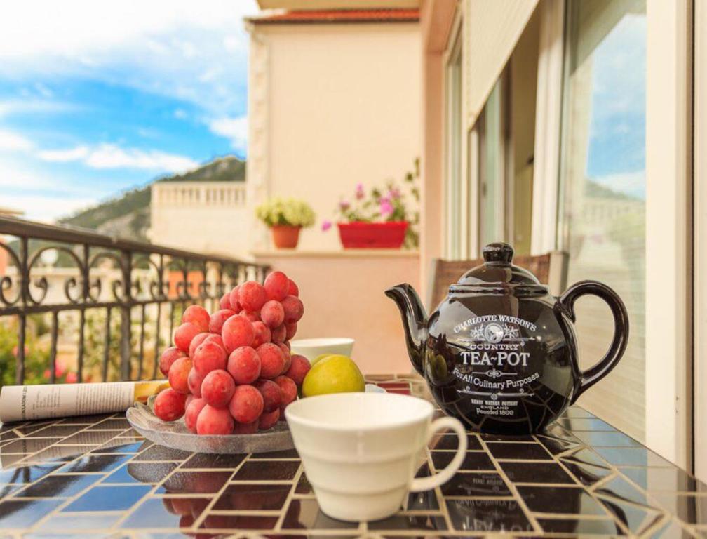 a table with a tea pot and a bowl of fruit at La Vita e Bella Apartment in Hvar