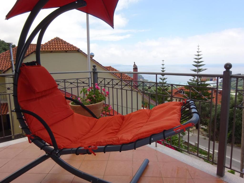 a red chair sitting on top of a balcony at Elena Rista Studios in Parga