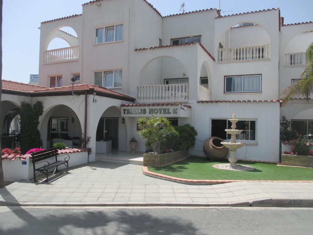 a large white building with a fountain in front of it at Tsialis Hotel Apartments in Larnaka