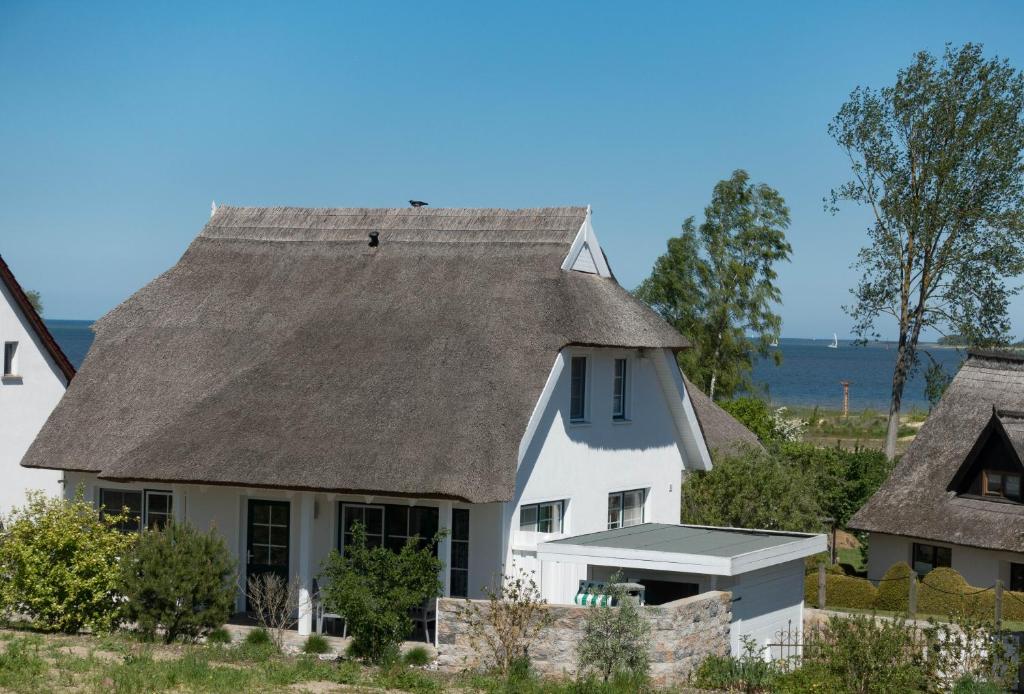 a white house with a gray roof at Reetdachhaus Strandecke in Freest