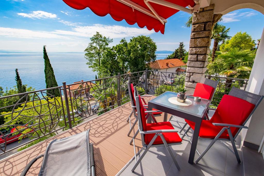 balkon ze stołem i krzesłami oraz oceanem w obiekcie Villa Tomić Apartment Mia near the sea w mieście Opatija